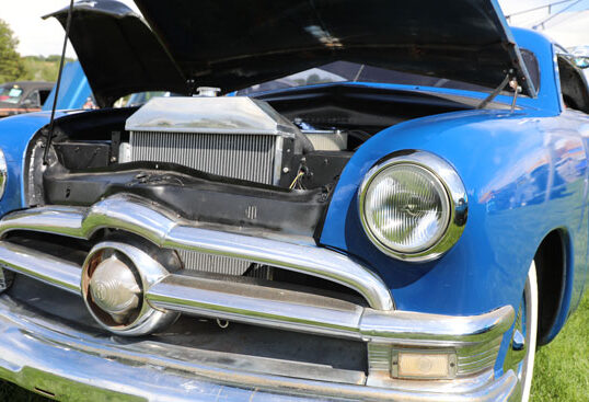 A blue, old, classic car at the annual fair and rodeo car show.