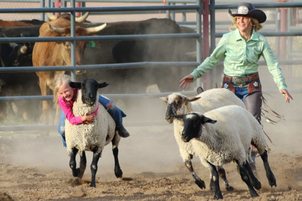 girl riding in the mutton bustin' competition