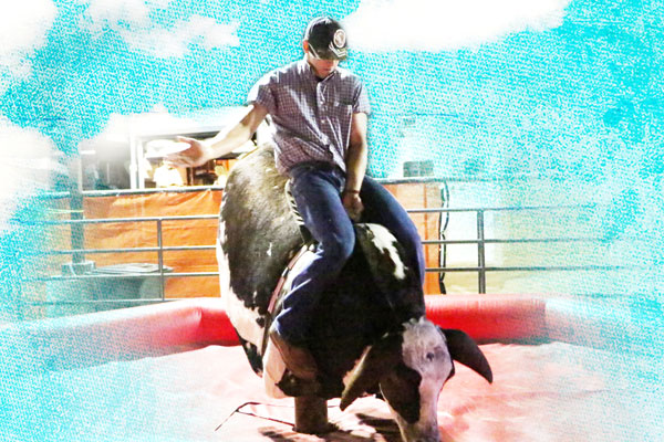 boy riding a mechanical bull